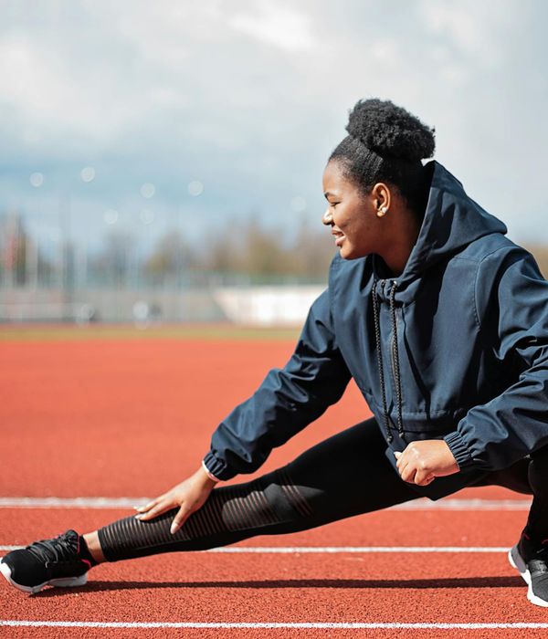 A focused woman in activewear performing a dynamic cardio exercise.