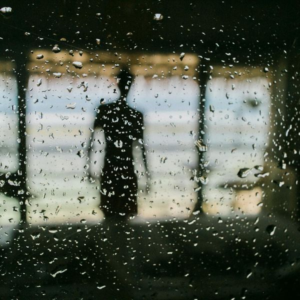 Silhouette of a person stretching against a calm, dark background.